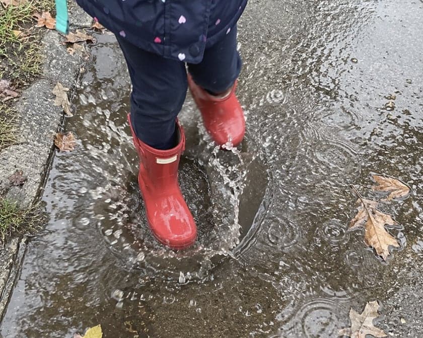 Sample timeline, photos AI-generated: a photo post on Riley’s timeline, a child’s red rain boots splashing in a puddle.